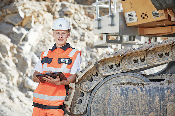 Azubi bedient Baumaschine mit externer Steuerung