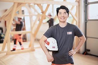 Azubi mit Bauhelm auf einer Baustelle