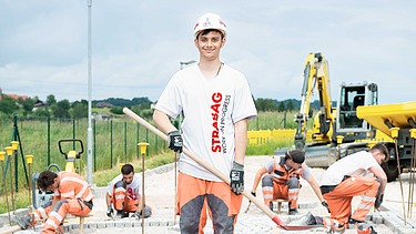 Strabag Karriere Header 07 Foto Vier Personen, der vordere mit Helm schaut in Kamera