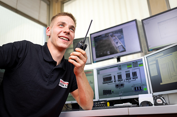 Azubi bedient Baumaschine mit externer Steuerung