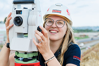 Foto einer Vermessungstechniker:in beim Vermessen