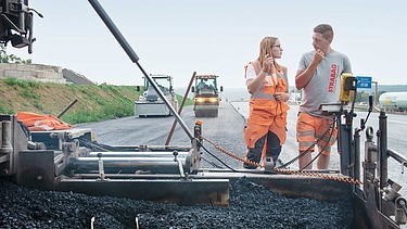 Arbeiter auf einer Maschine im Straßenbau