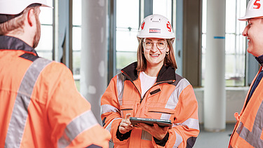 Zwei Kolleg:innen beim arbeiten auf einer Baustelle