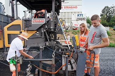 Foto Auszubildender vor zu pflasternder Fläche