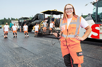 Auszubildende beim Asphaltieren auf der Baustelle