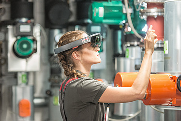 Foto ein Mitarbeiter und eine Mitarbeiterin beim Betrachten eines Bauplans