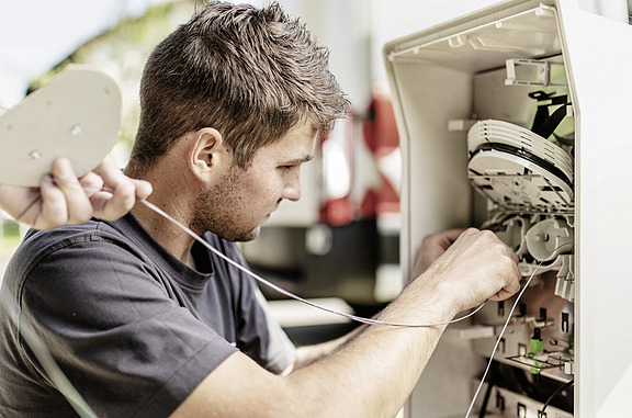 Junger Mann arbeitet an einem elektronischen Schaltkasten