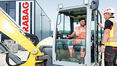 Junger Mann auf einem Baugerät