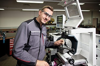 Ausbildung als Industriemechaniker:in Azubi arbeitet an einer Maschine